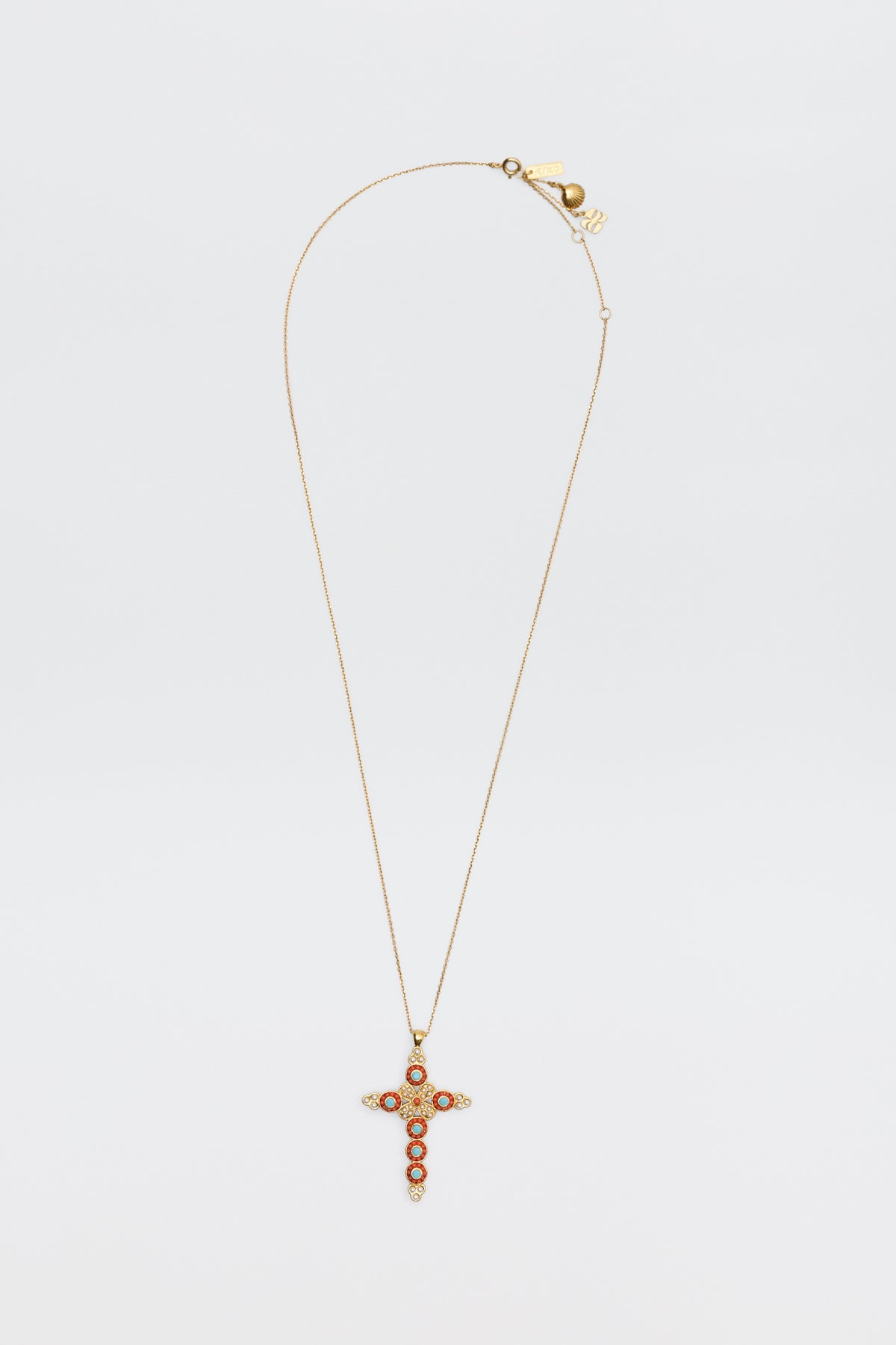 The Lenka - Gold necklace features a gold chain with a cross pendant embellished with red and clear stones, shown against a plain white background.