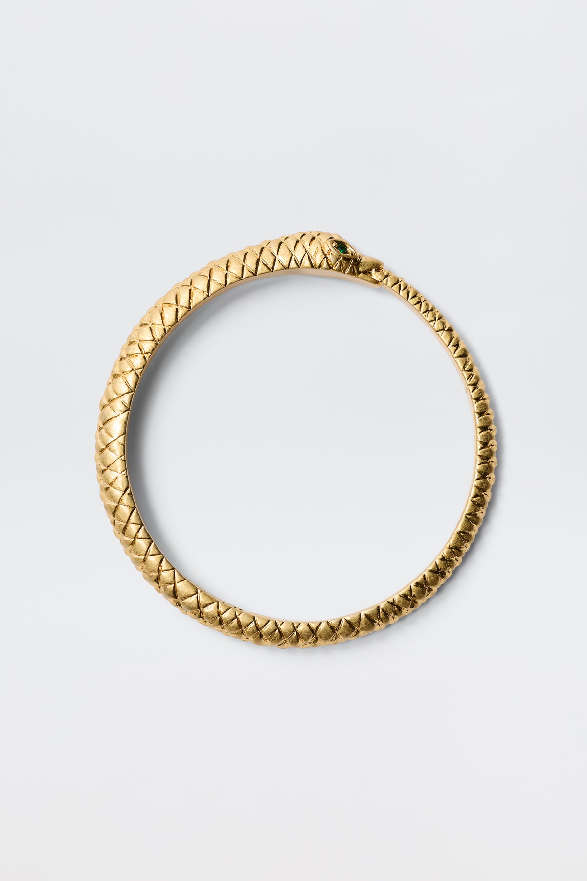 The Viera - Gold is a gold-plated snake bangle in a circular shape, designed as a serpent eating its tail with detailed scales and an antique finish. Displayed on a plain light gray background, it represents the ouroboros.