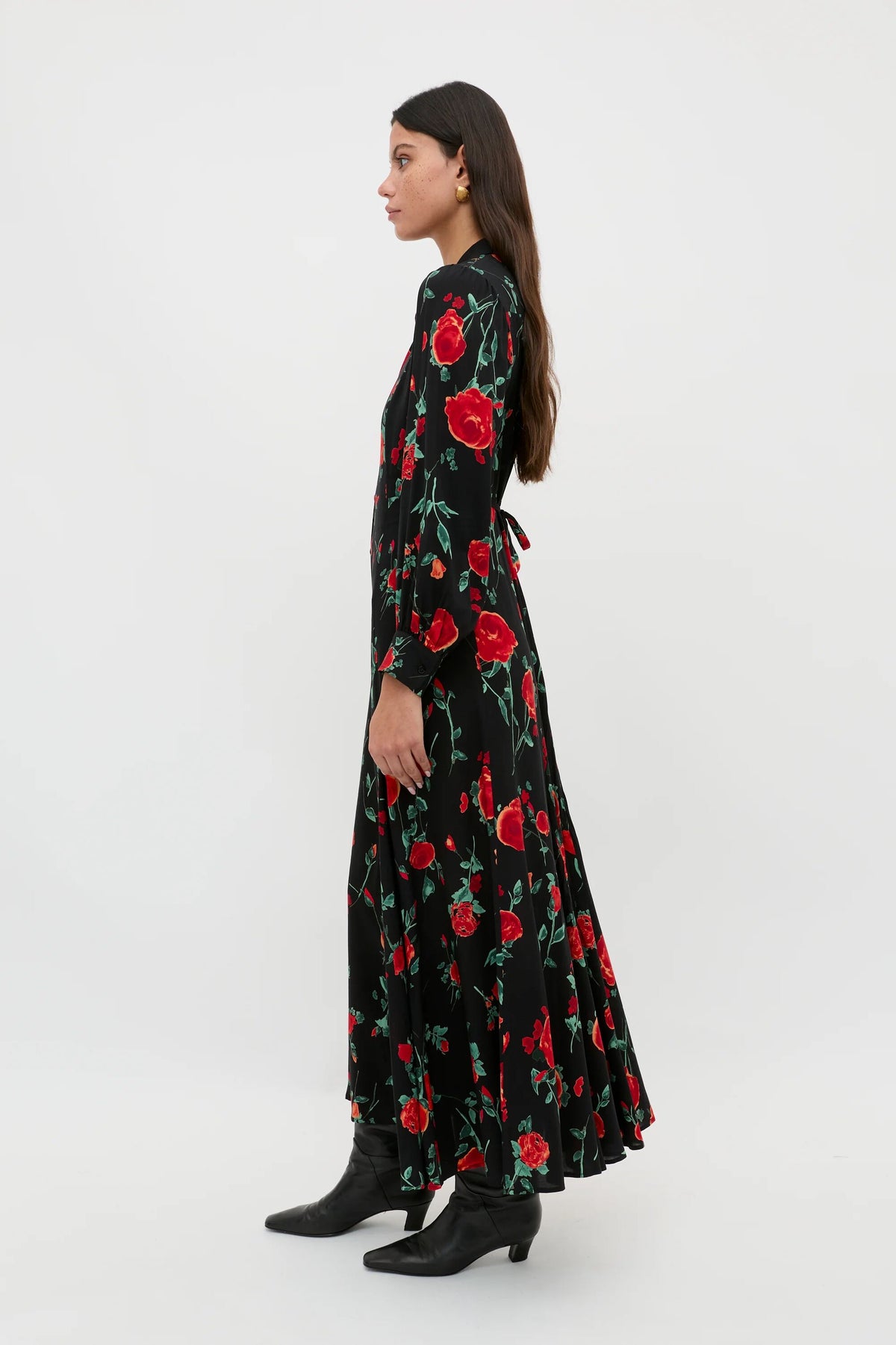 A petite woman in profile wears the Maddison - Claudia Rose Black shirt dress paired with black boots. She has long dark hair and faces left against a plain white background, showcasing effortless everyday style.