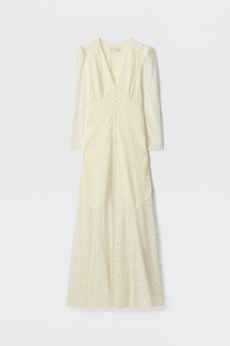 The Fleur - Ivory is a long-sleeved, floor-length ivory corded lace dress with a V-neckline, covered front buttons, and a subtle fit-and-flare silhouette, shown on a plain white background.