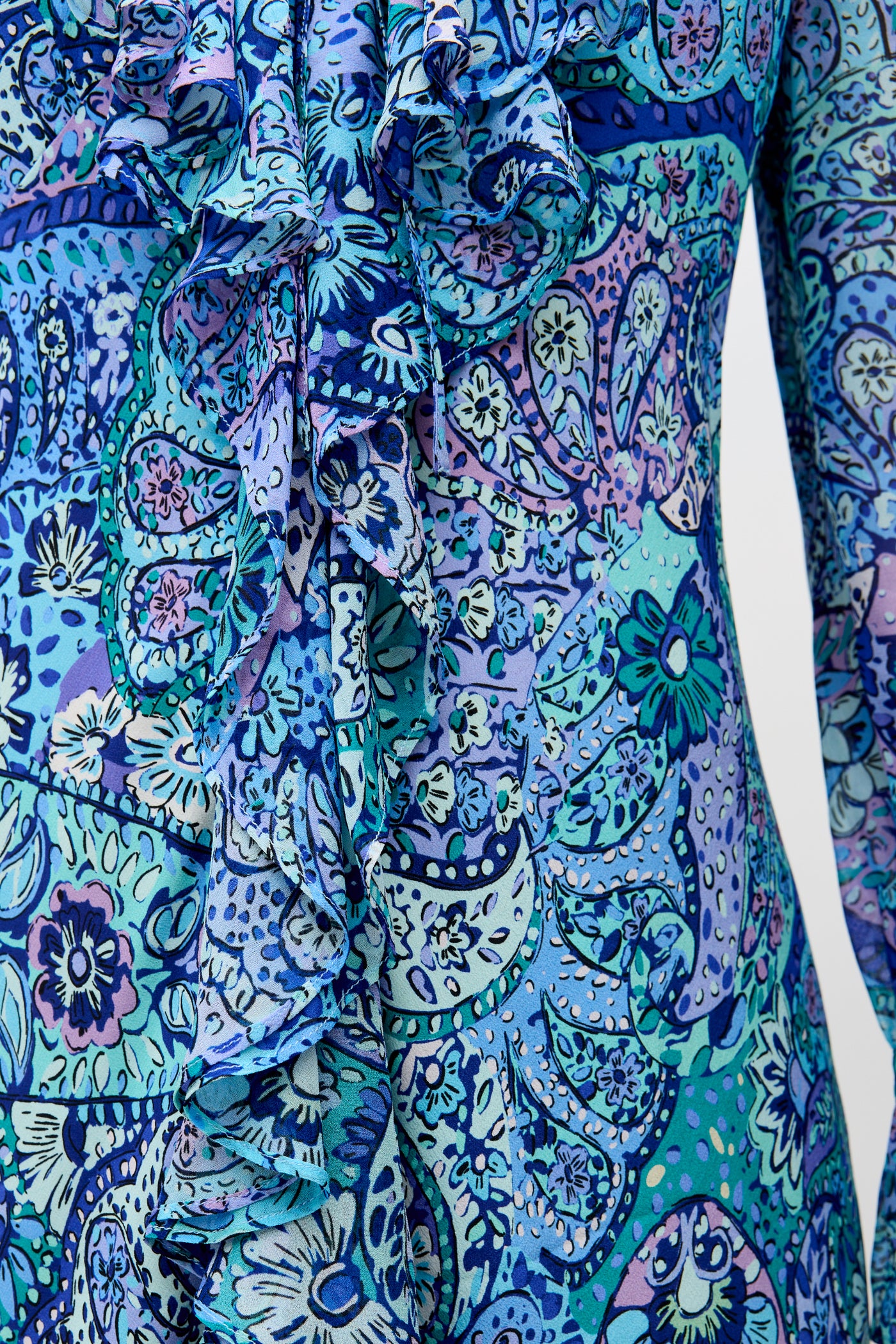 Close-up of the Gracye - Paisley Floral Blue, featuring vibrant blue, teal, and purple paisley patterns with floral motifs and ruffled detailing on the upper body of a long-sleeve garment.
