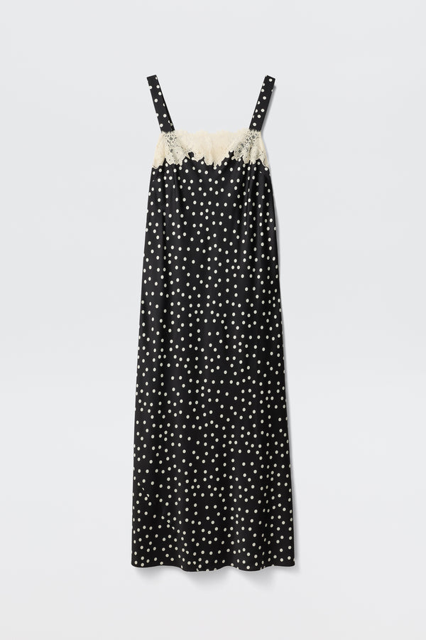 The Rosamarie - Scattered Dot Black is a black sleeveless slip dress featuring white polka dots and cream lace trim along the top edge, shown against a plain white background.