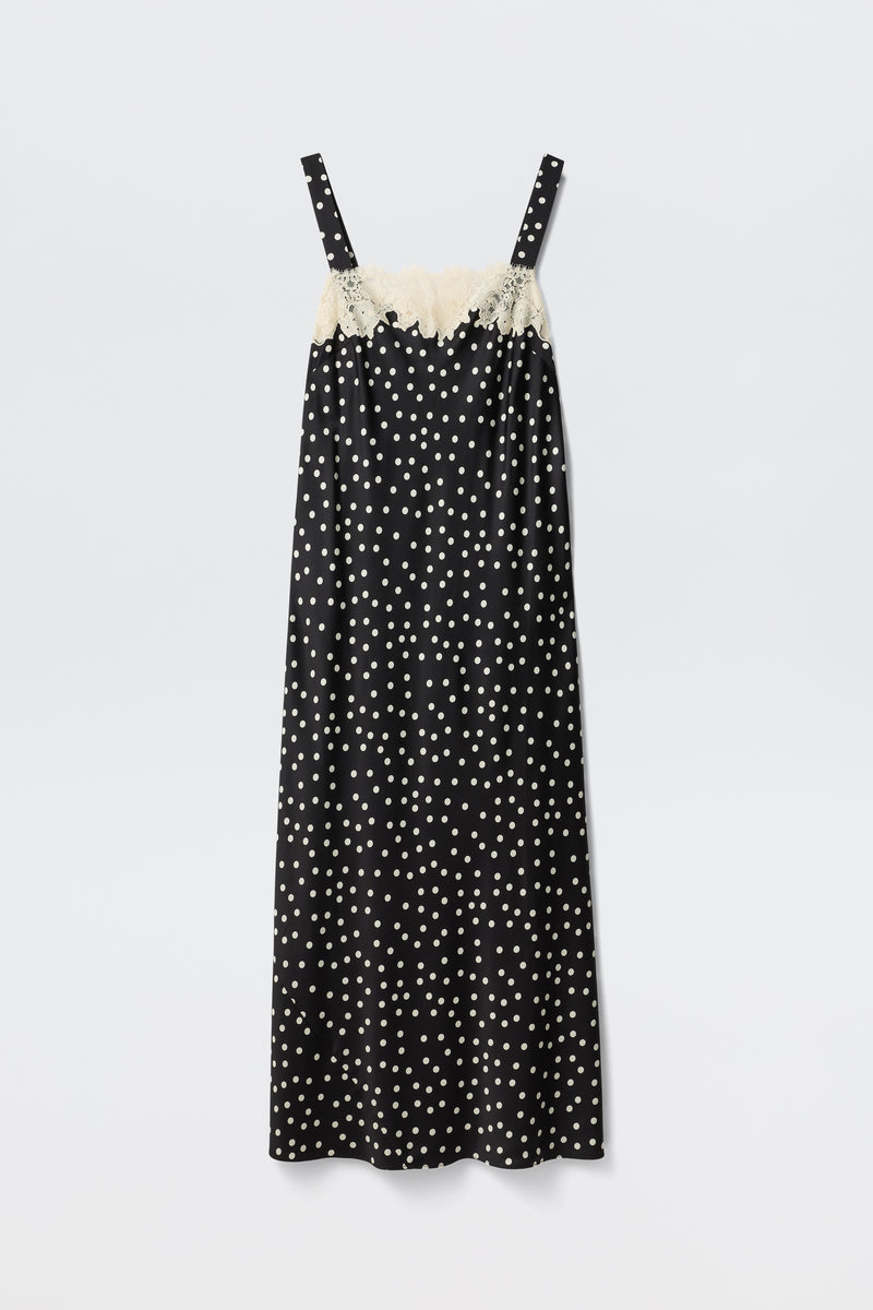 The Rosamarie - Scattered Dot Black is a black sleeveless slip dress featuring white polka dots and cream lace trim along the top edge, shown against a plain white background.