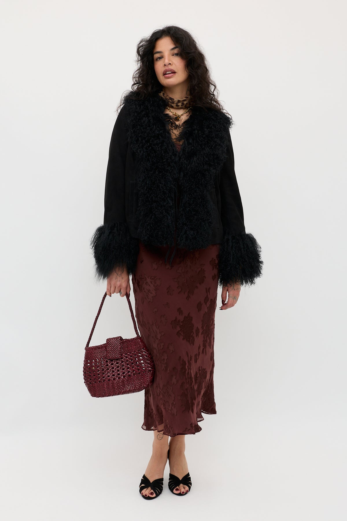 A woman wearing the Noraya - Bouquet Devoré Brown coat and holding a purse.