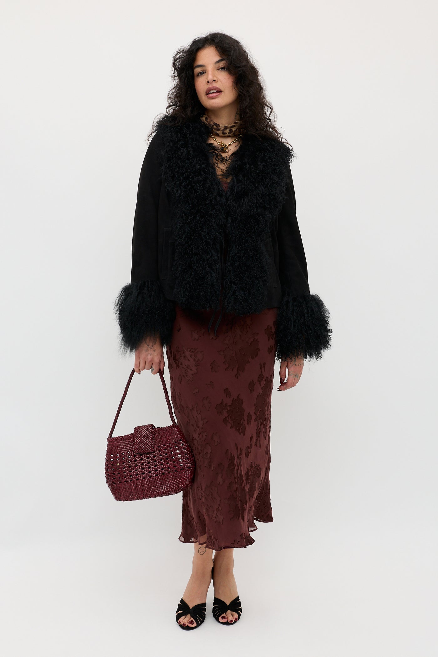 A woman wearing the Noraya - Bouquet Devoré Brown coat and holding a purse.