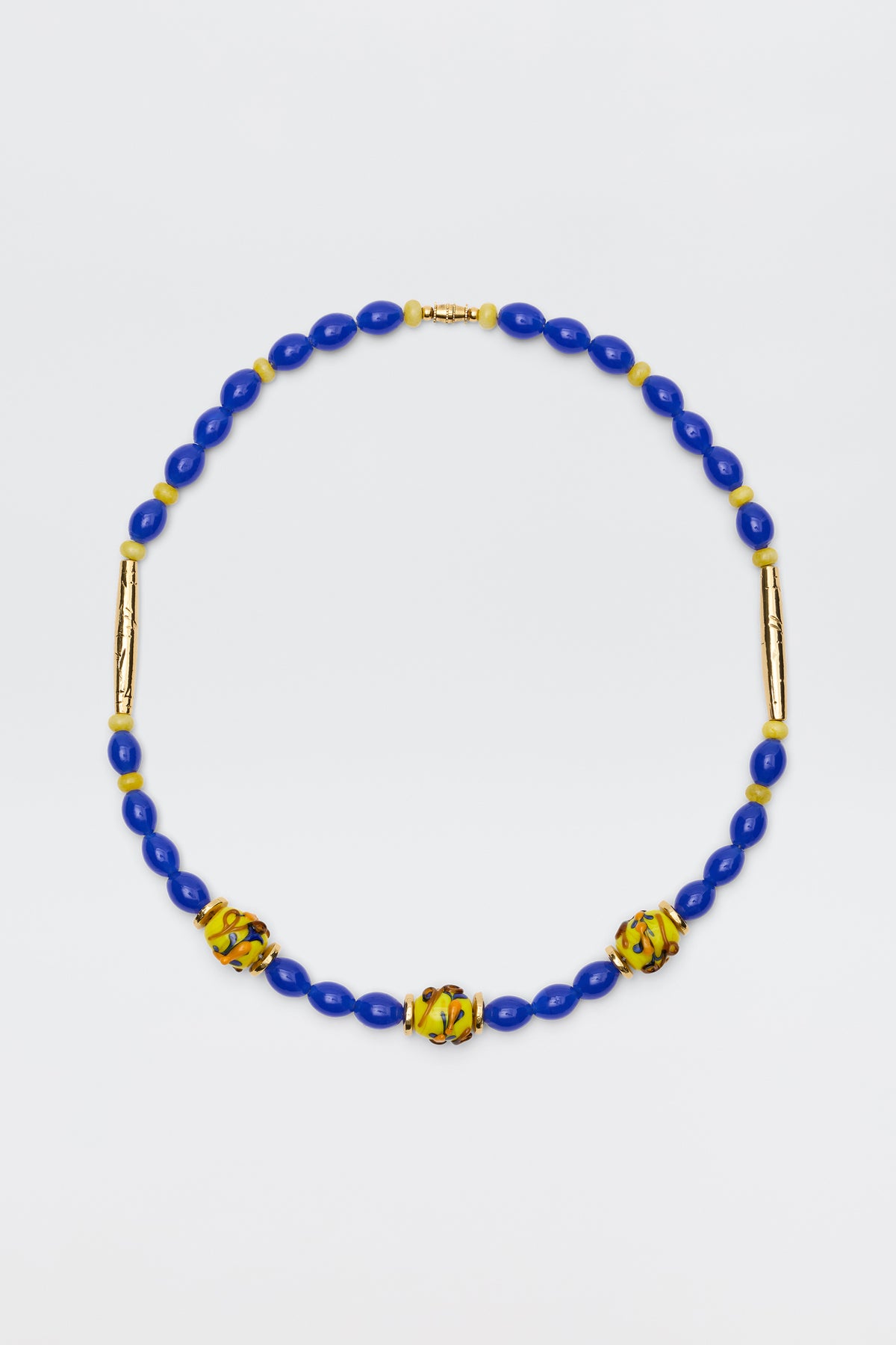 Denali - Multi necklace featuring blue oval beads, three yellow and green patterned round beads, and two gold-plated bead accents, beautifully displayed on a white background.