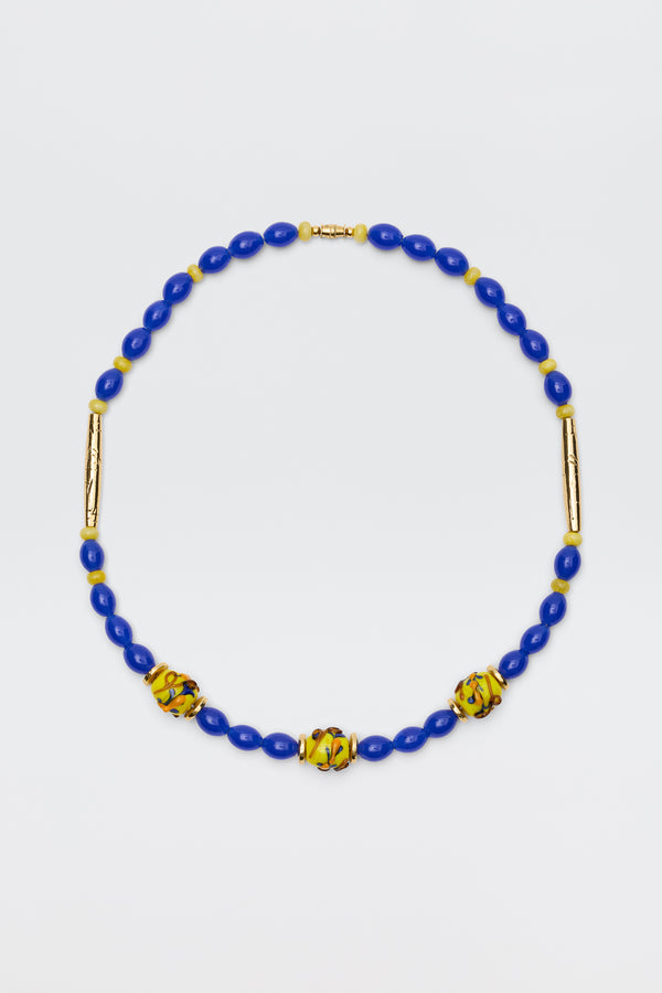 Denali - Multi necklace featuring blue oval beads, three yellow and green patterned round beads, and two gold-plated bead accents, beautifully displayed on a white background.