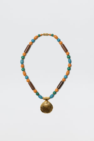 The Darielle - Multi necklace features alternating turquoise, brown wooden, and orange beads with a gold seashell pendant at the center, shown on a plain white background.