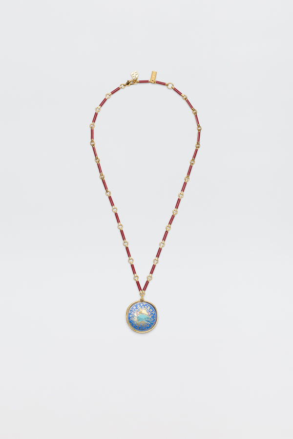 The Ari - Astro Cancer necklace features gold statement disc charms with alternating red and gold links and a round blue-and-gold sunburst pendant. Ideal as a zodiac necklace, it's shown on a plain white background.