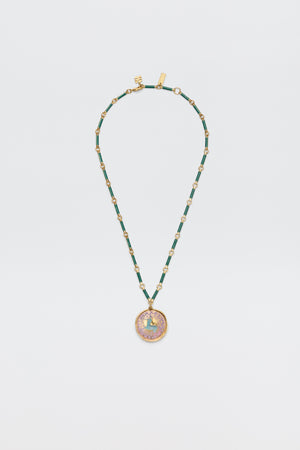 Ari - Astro Sagittarius: A gold and green beaded necklace with an ornate, round pendant featuring an intricate Sagittarius design, shown on a plain white background.