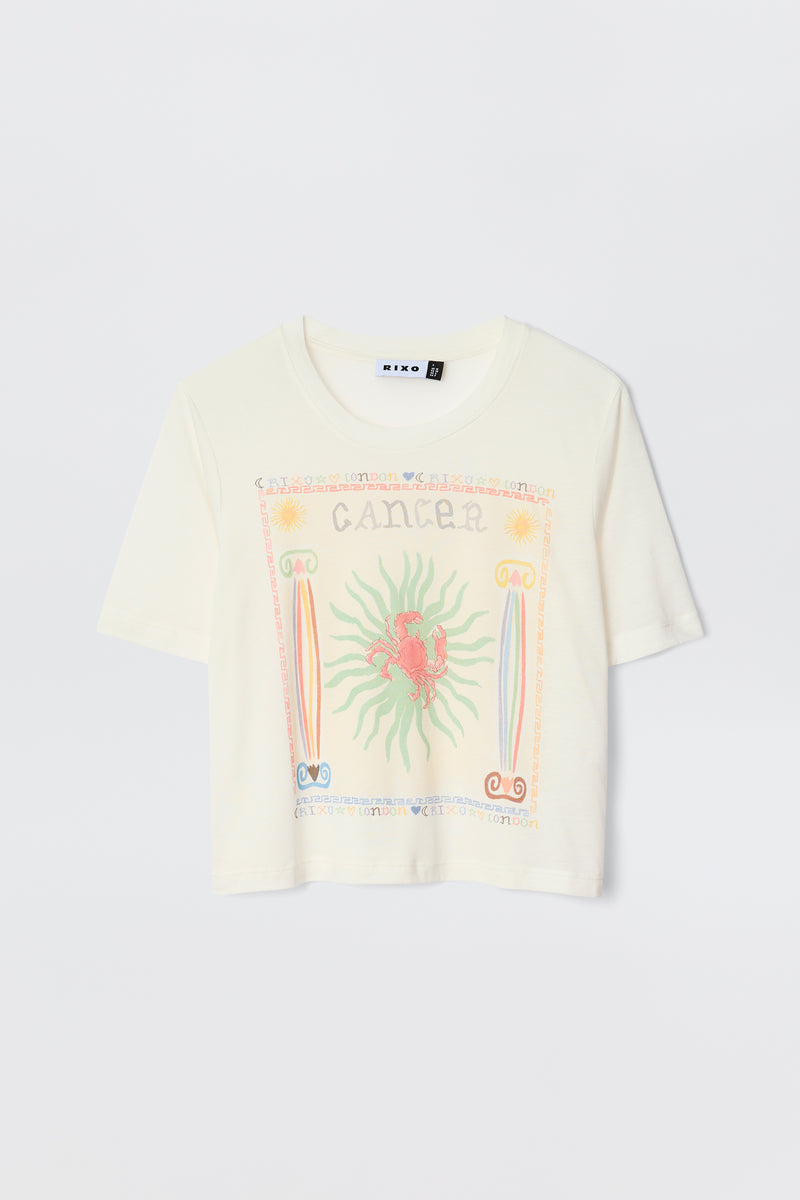The Ria - Cancer T-shirt is a white short-sleeve top with a vibrant red crab Cancer illustration, pastel border designs, and "Cancer" text—perfect to pair with playful RIXO skirts.