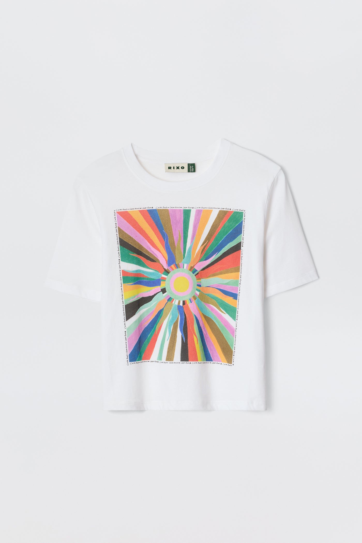 The Ria-Casa Soleil Multi T-shirt features a white base with a vibrant, abstract sunburst design and radiating colorful lines on the front, finished with a trendy cropped hem.