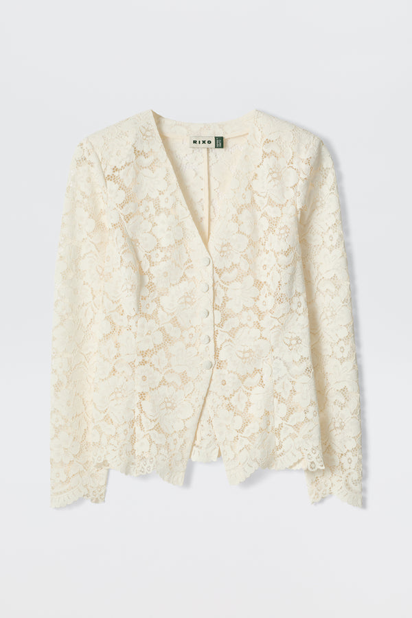 The Padma - Cream is an off-white, long-sleeved lace cardigan with a V-neckline and delicate floral pattern, shown flat on a light background.