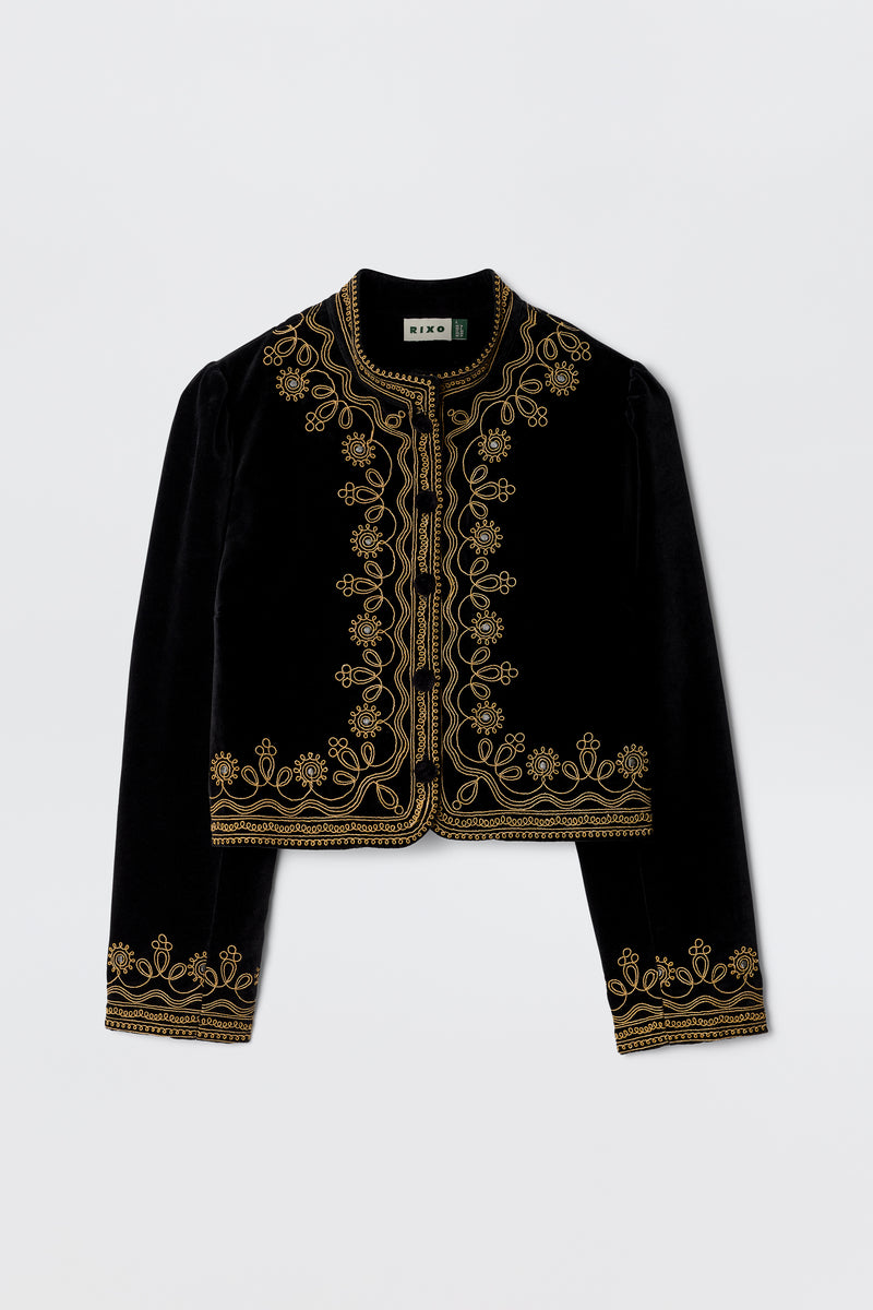 The Denver - Soutache Black jacket is crafted from soft cotton-velvet in black, detailed with gold embroidery on the collar, front opening, cuffs, and hem. Shown against a plain white background.
