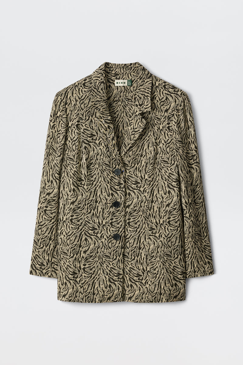Marselle - Sun Leo Tan features a beige and black leaf-patterned blazer with three black buttons, notched lapels, and long sleeves, showcased on a plain white background.