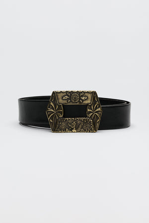 The Rhianna - Black is a black leather belt with a large, ornate brass buckle adorned with decorative engravings and geometric patterns, showcased against a plain white background.