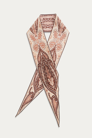 The Yelina - Paisley Flora Brown scarf is made of silk and showcases brown and peach paisley floral patterns on a beige background, arranged in a crisscrossed, pointed design against white.