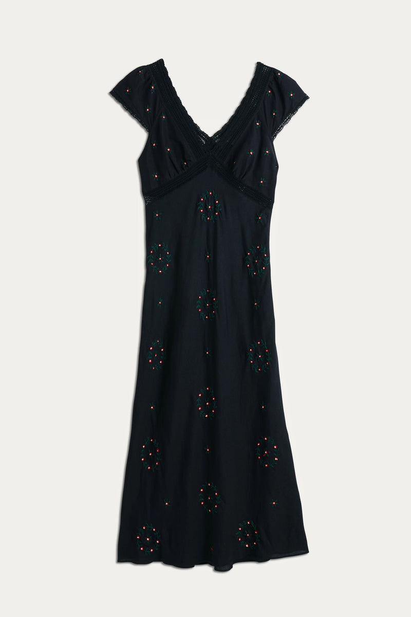 The Iggy - Rose Trail Embroidery Black dress features a black short-sleeve V-neck design with cotton lace trim and colorful beaded embroidery. Its fitted waist and gently flared skirt make it a versatile choice for any occasion.