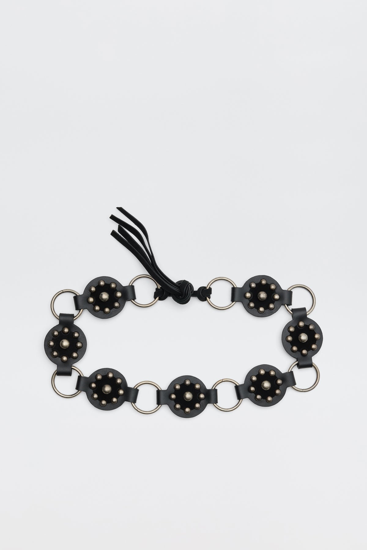 Introducing Kassy - Black: a black bracelet composed of circular segments adorned with small gold studs, linked by silver rings, and finished with a black string tie.